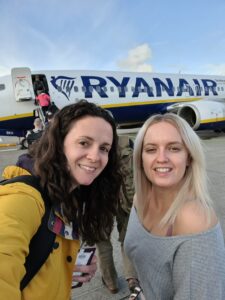 Two woman standing in front of a Ryanair plane