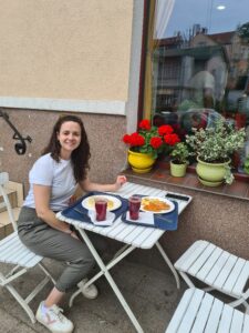 Woman sitting at outdoor table with trays of food