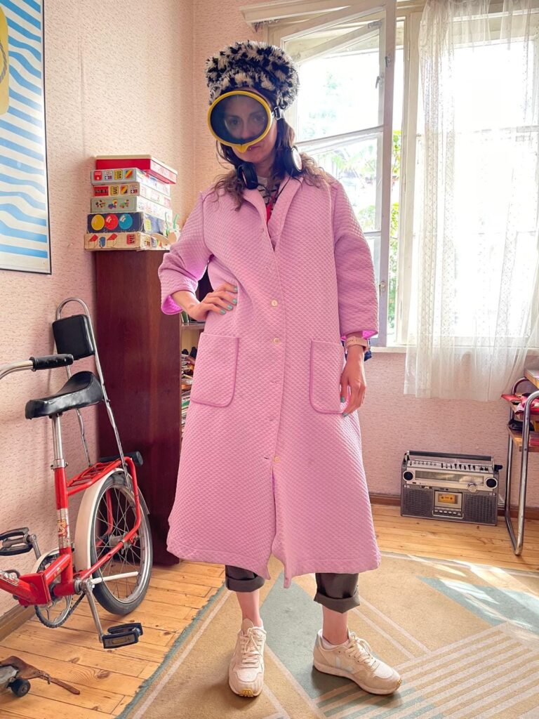 Woman dressed in a silly outfit of light pink house coat and snorkel mask